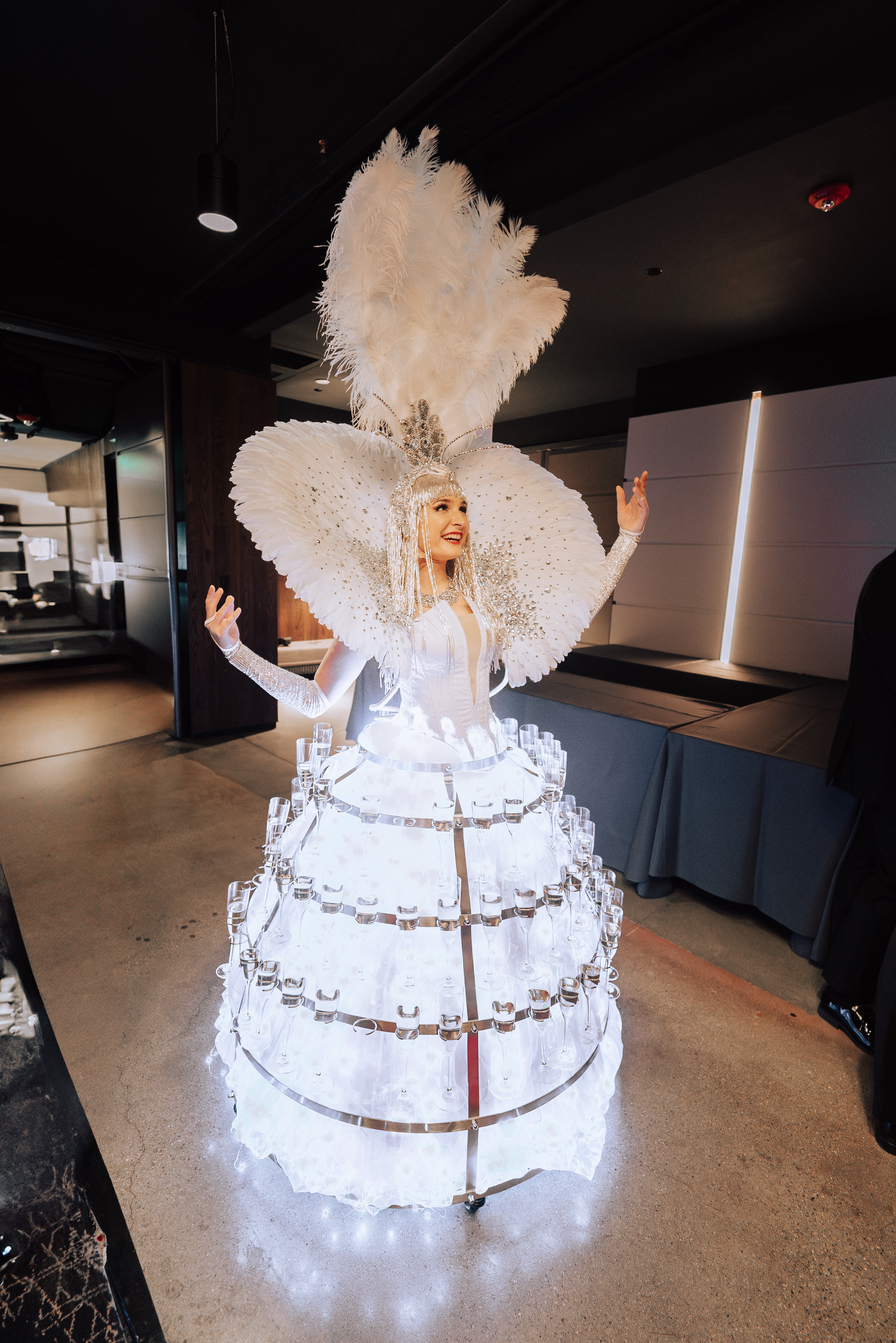 Strolling champagne skirt diva serving champagne at a high-end event in Boston, wearing an elegant costume and engaging guests with a unique interactive experience; ideal entertainment for weddings, corporate events, and luxury celebrations in cities like New York, Chicago, and Miami.